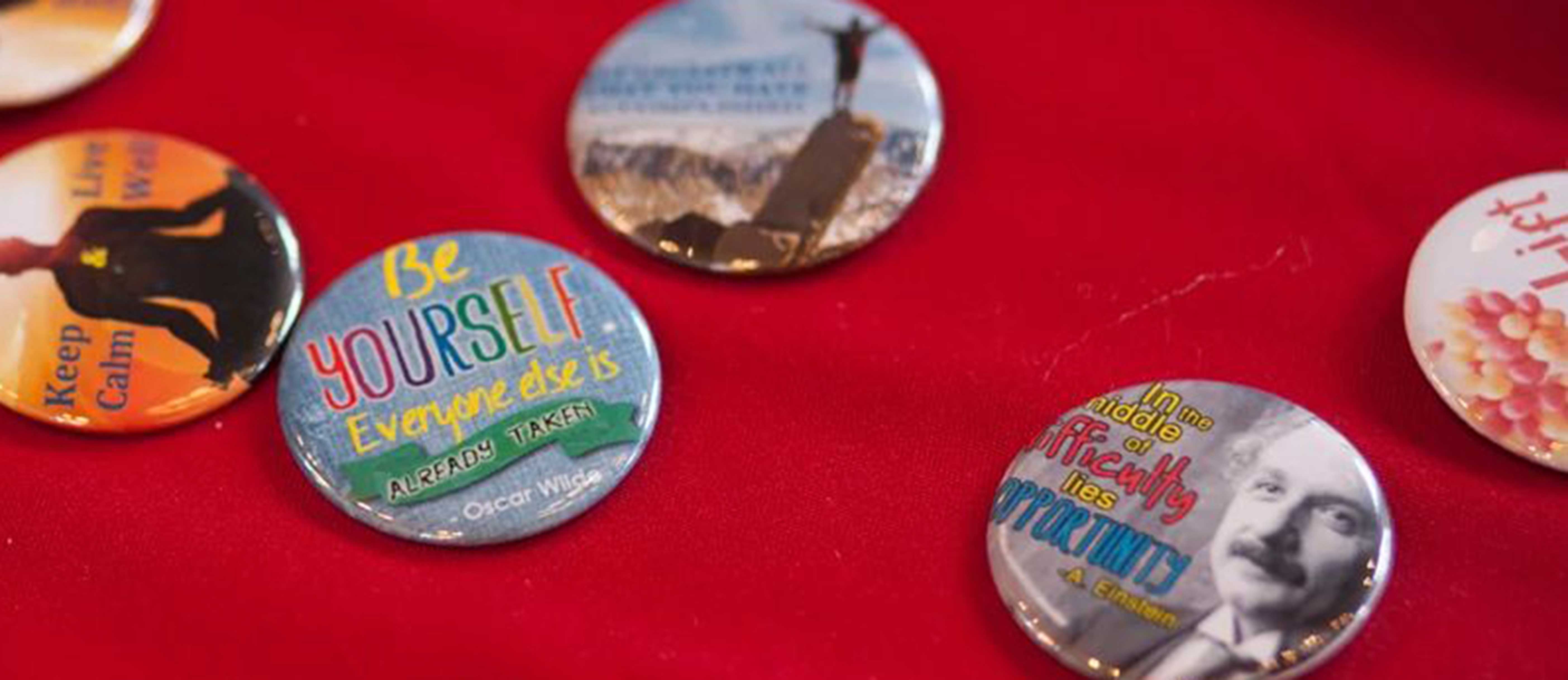 Buttons with inspirational sayings displayed on table at "Cornell Lifted" event